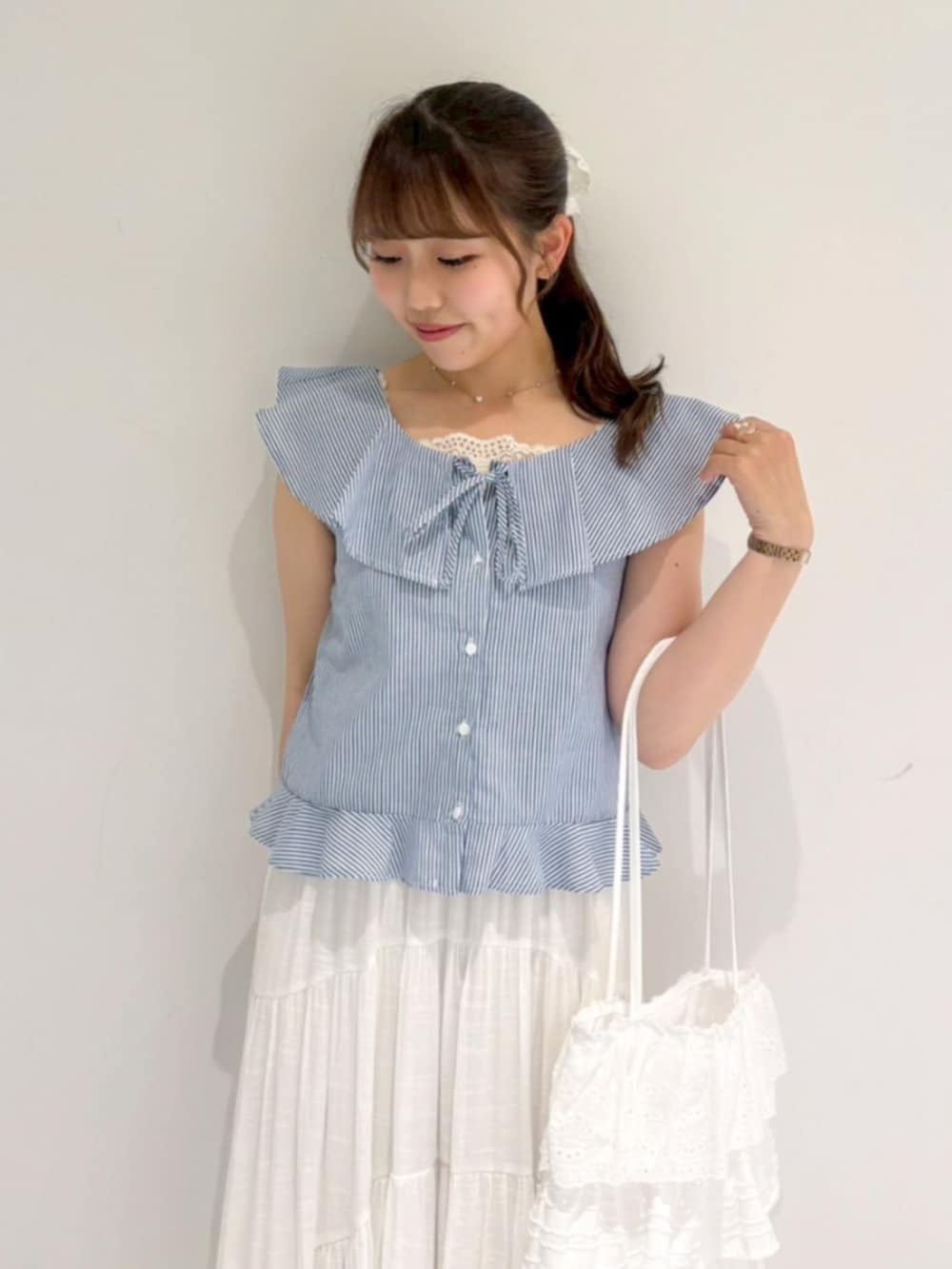 ホワイト系のトートバッグ、ホワイト系のスカート、ブルー系のシャツ/ブラウスを着用したレディースの夏コーディネートの2枚目の写真