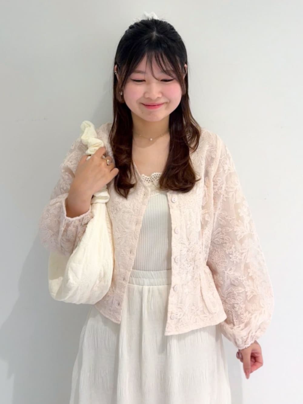 ホワイト系のショルダーバッグ、ホワイト系のキャミソール、ホワイト系のスカートを着用したレディースの春コーディネートの2枚目の写真