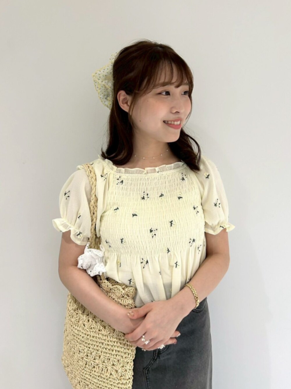 ブラック系のデニムスカート、イエロー系のシャツ/ブラウス、ベージュ系のトートバッグを着用したレディースの夏コーディネートの2枚目の写真