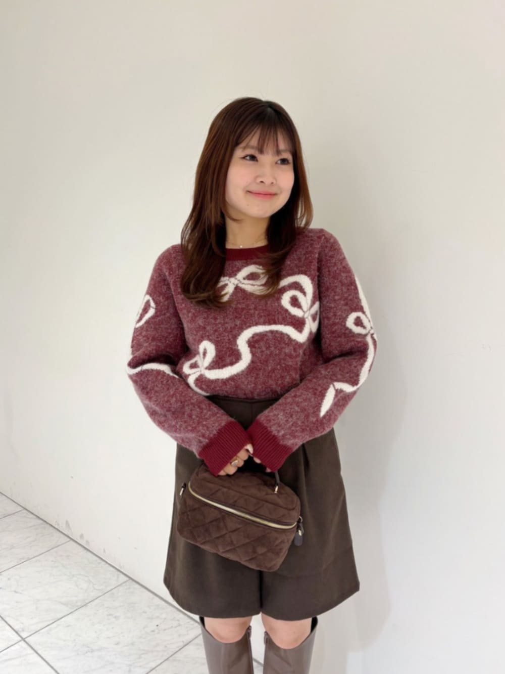 ブラウン系のその他パンツ、ブラウン系のショルダーバッグ、レッド系のニット/セーターを着用したレディースの秋コーディネートの2枚目の写真