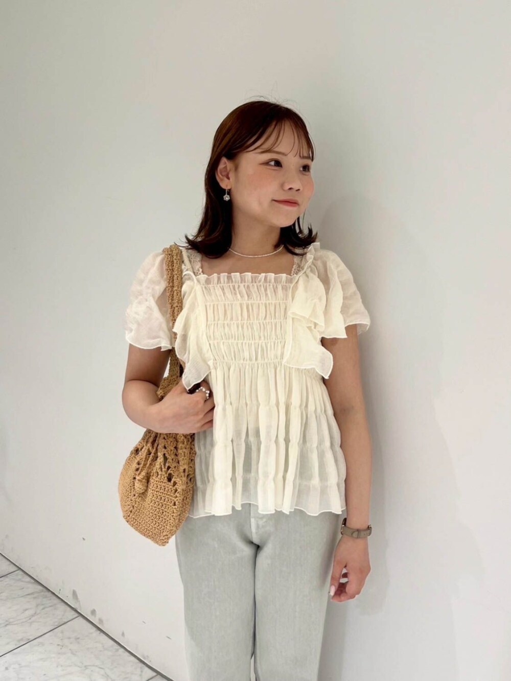 ホワイト系のシャツ/ブラウス、ブラウン系のショルダーバッグ、グリーン系のデニムパンツを着用したレディースの夏コーディネートの2枚目の写真