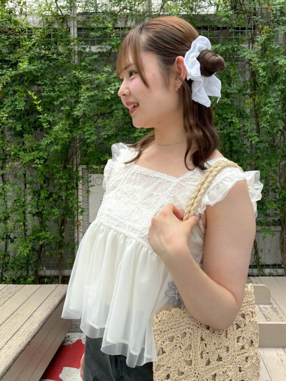 ベージュ系のかごバッグ、ブラック系のデニムパンツ、ホワイト系のシャツ/ブラウスを着用したレディースの夏コーディネートの2枚目の写真