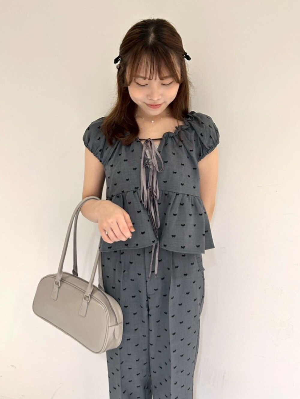 グレー系のキャミソール、グレー系のその他パンツ、グレー系のショルダーバッグを着用したレディースの秋コーディネートの2枚目の写真