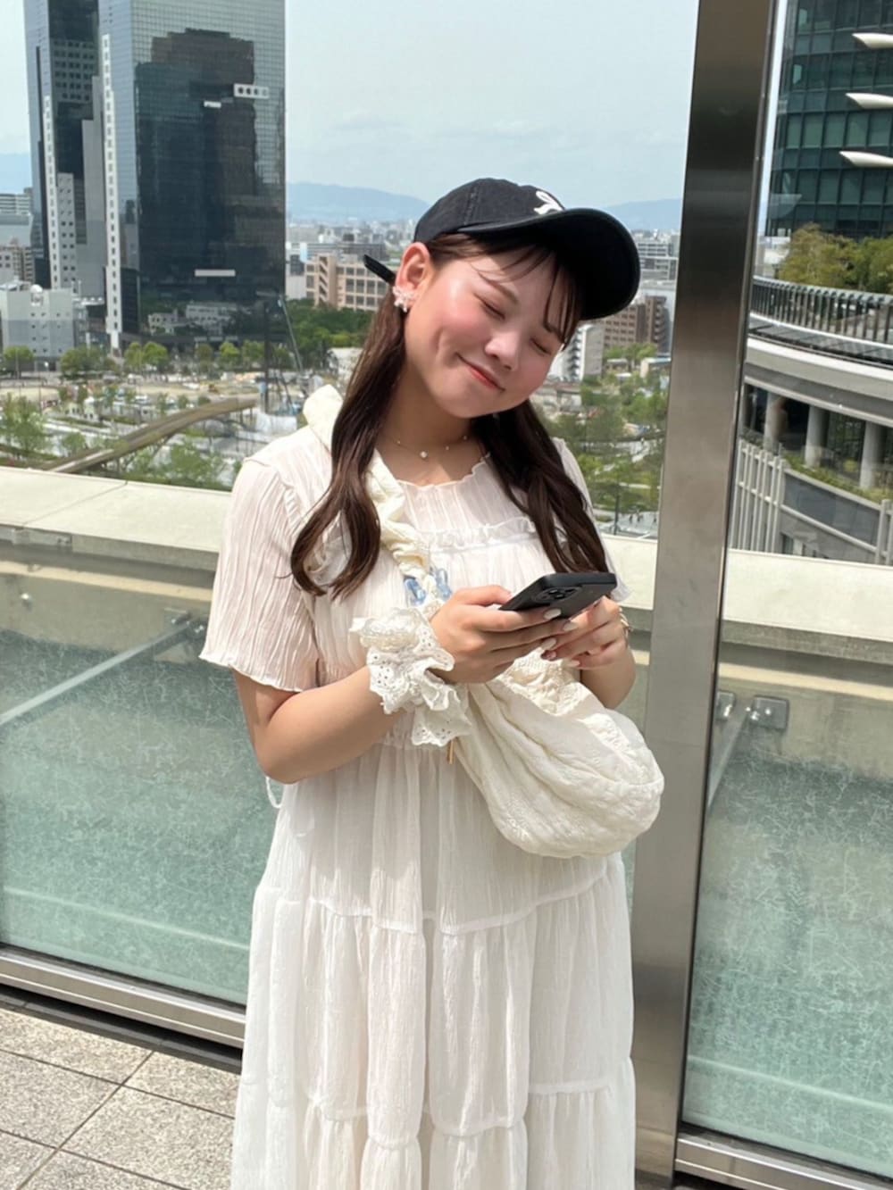 ブルー系のデニムパンツ、ホワイト系のTシャツ/カットソー、ホワイト系のショルダーバッグを着用したレディースの春コーディネートの2枚目の写真