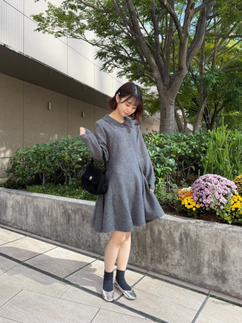 ブラック系のショルダーバッグ、ホワイト系のノーカラーコート、グレー系のワンピース/ドレスを着用したレディースの秋コーディネートの2枚目の写真
