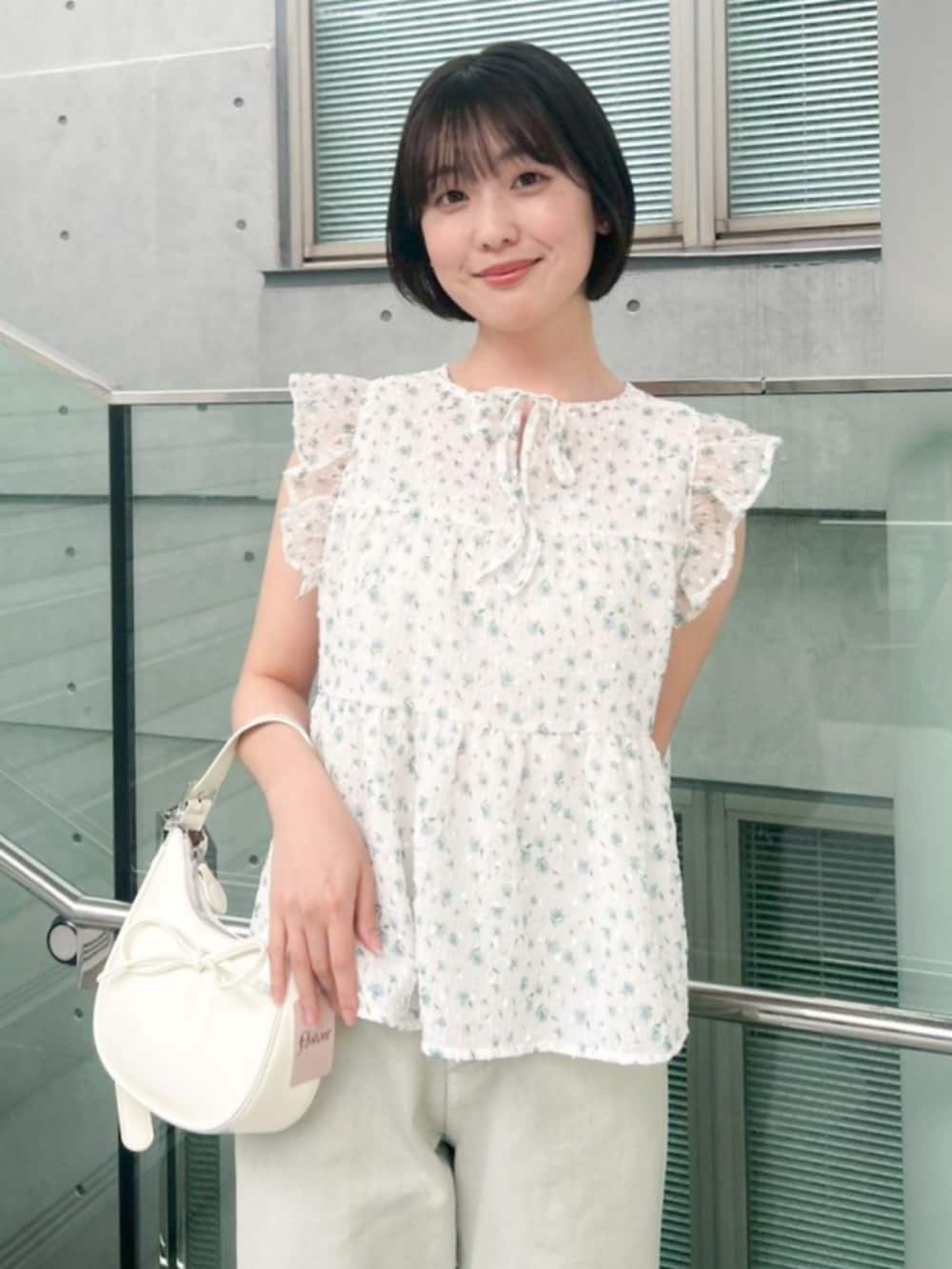 グリーン系のデニムパンツ、ホワイト系のショルダーバッグ、ブルー系のシャツ/ブラウスを着用したレディースの夏コーディネートの2枚目の写真