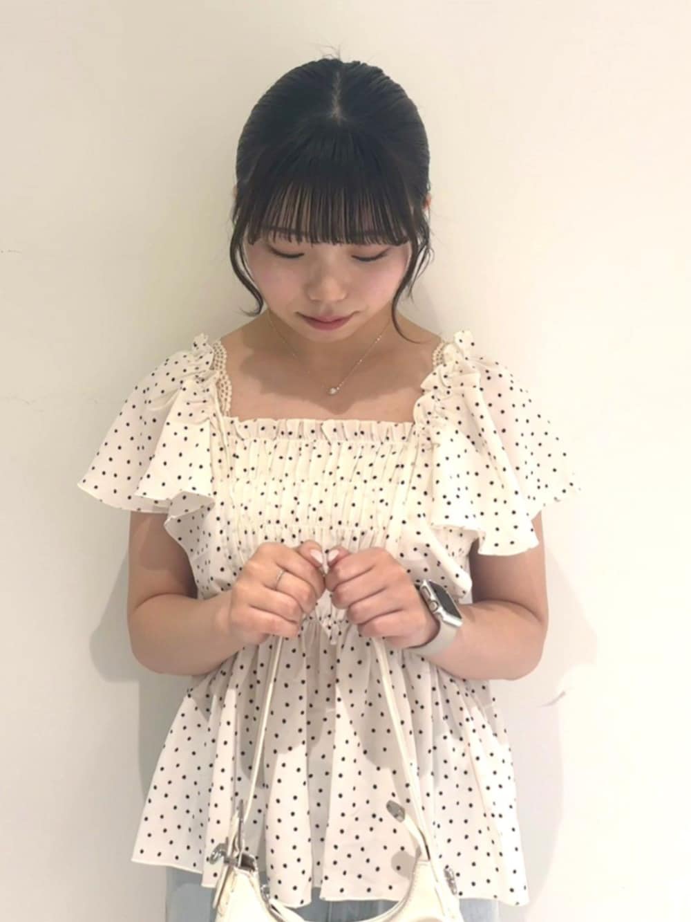 ブルー系のデニムパンツ、ホワイト系のショルダーバッグ、ホワイト系のシャツ/ブラウスを着用したレディースの春コーディネートの2枚目の写真