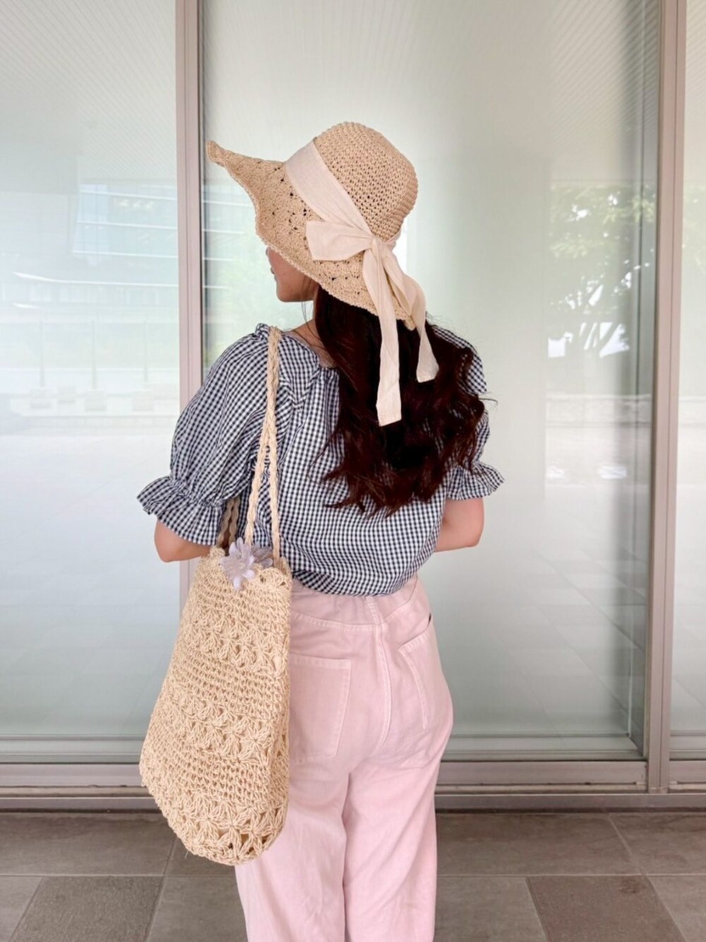 ブルー系のシャツ/ブラウス、ベージュ系のトートバッグ、ピンク系のデニムパンツを着用したレディースの春コーディネートの3枚目の写真