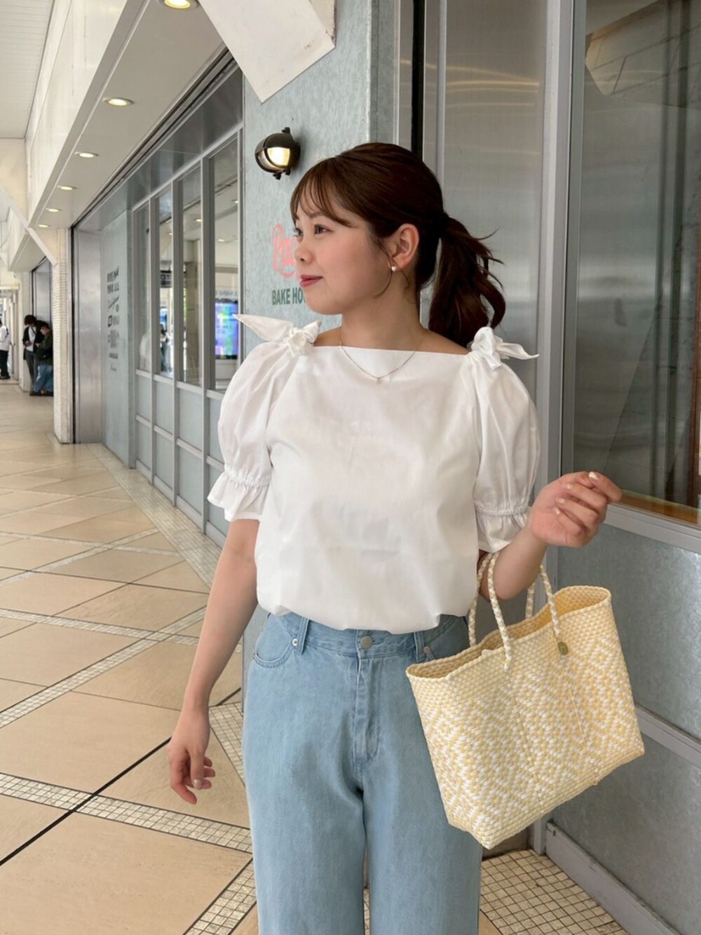 ブルー系のデニムパンツ、ホワイト系のシャツ/ブラウス、ゴールド系のピアス（片耳用）を着用したレディースの春コーディネートの3枚目の写真