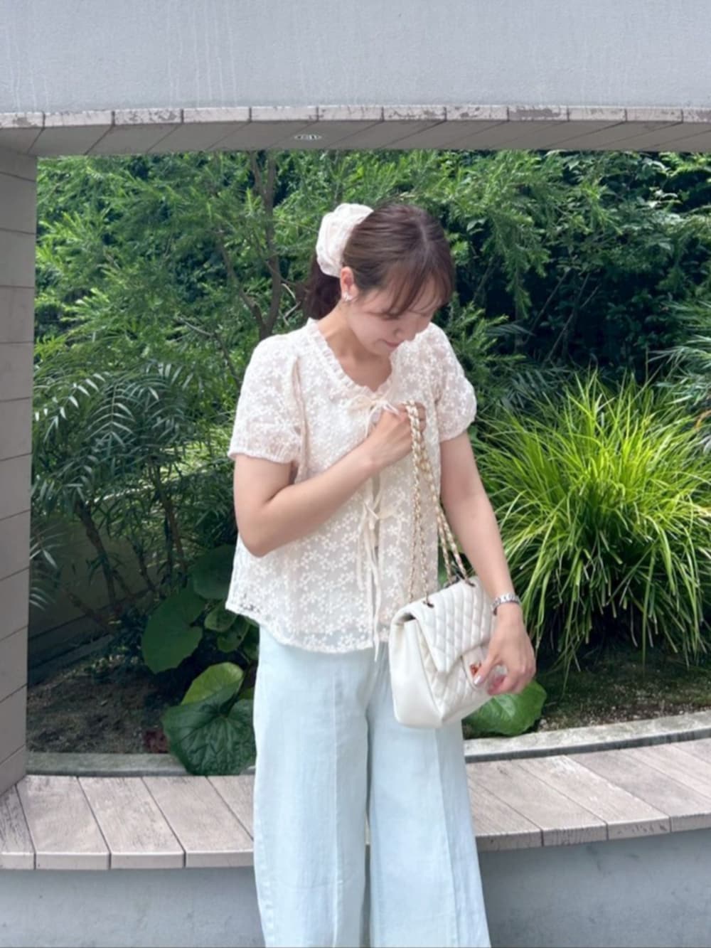 ホワイト系のショルダーバッグ、ブルー系のデニムパンツ、ピンク系のシャツ/ブラウスを着用したレディースの夏コーディネートの2枚目の写真