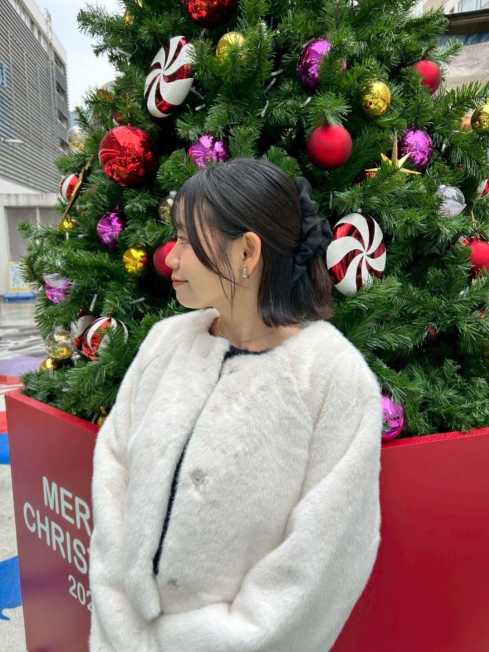 ホワイト系のノーカラーコート、グレー系のワンピース、ブルー系のニット/セーターを着用したレディースの冬コーディネートの3枚目の写真