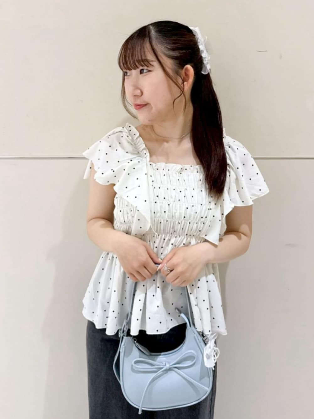 ブラック系のデニムパンツ、ブルー系のショルダーバッグ、ホワイト系のシャツ/ブラウスを着用したレディースの夏コーディネートの2枚目の写真