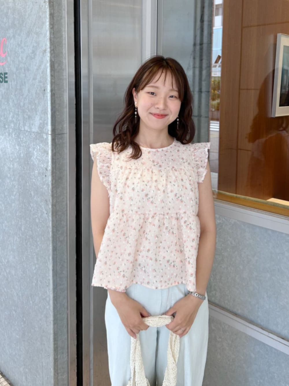 ホワイト系のショルダーバッグ、ブルー系のデニムパンツ、オレンジ系のシャツ/ブラウスを着用したレディースの夏コーディネートの2枚目の写真