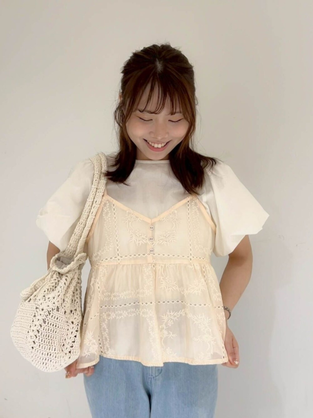 ブルー系のデニムパンツ、ピンク系のキャミソール、ホワイト系のシャツ/ブラウスを着用したレディースの夏コーディネートの2枚目の写真