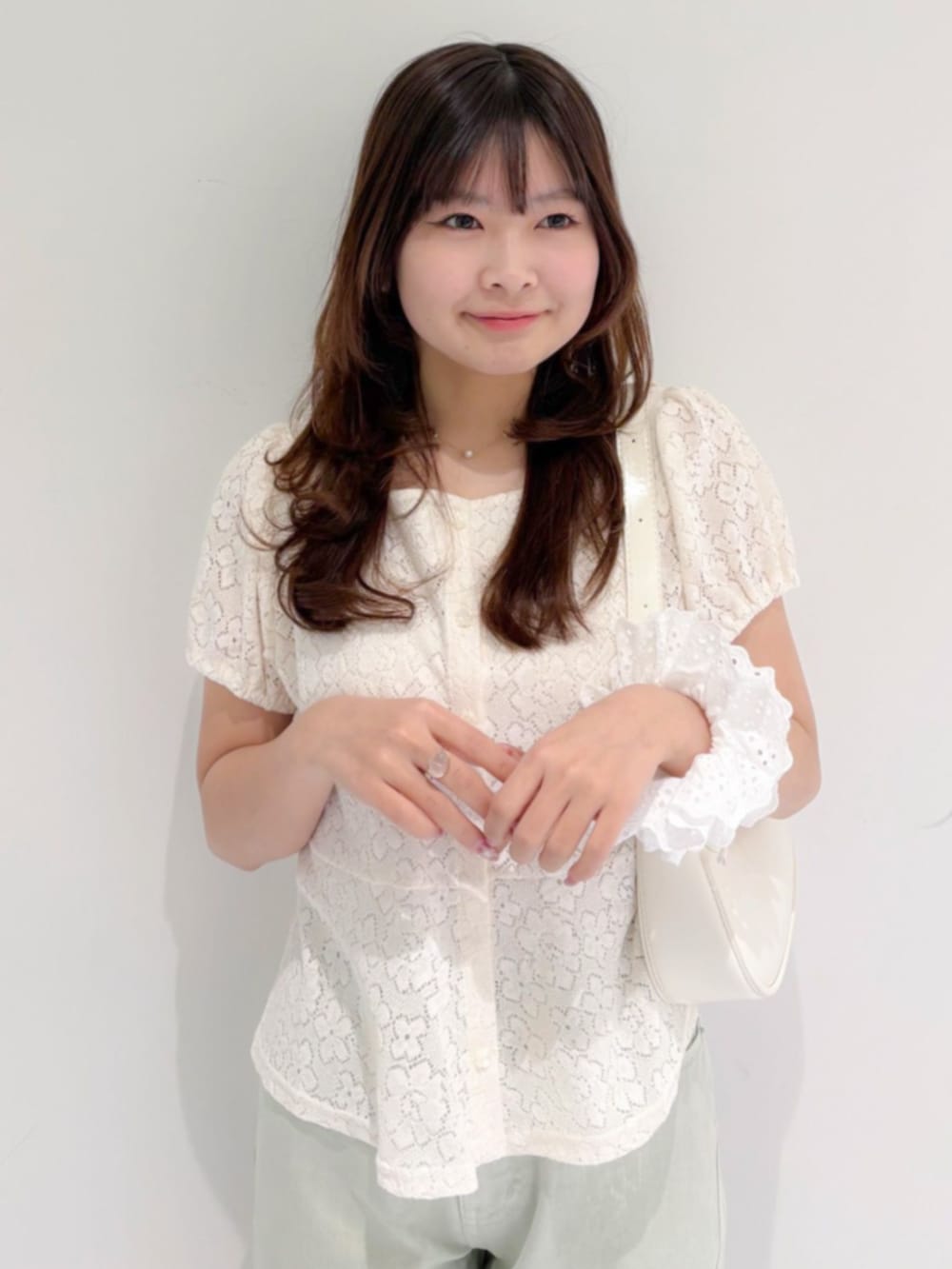 グリーン系のデニムパンツ、ホワイト系のショルダーバッグ、ホワイト系のシャツ/ブラウスを着用したレディースの春コーディネートの2枚目の写真