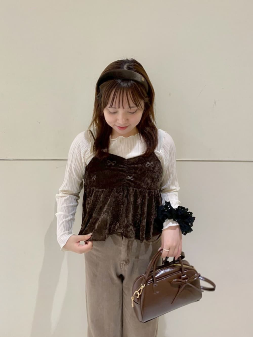 ホワイト系のTシャツ/カットソー、ブラウン系のキャミソール、ブラウン系のデニムパンツを着用したレディースの秋コーディネートの2枚目の写真