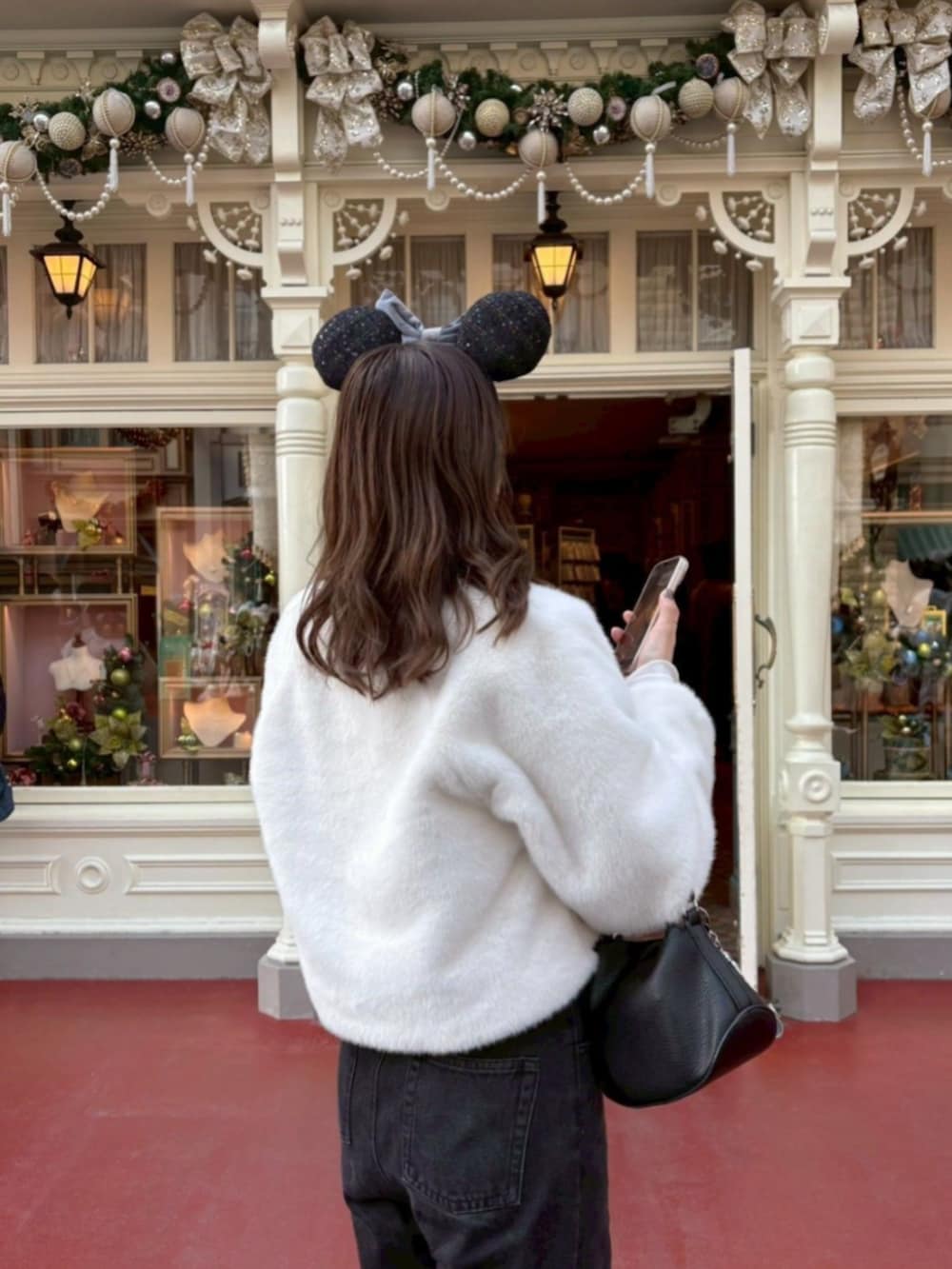 ブラック系のデニムパンツ、ホワイト系のノーカラーコート、グレー系のマフラーを着用したレディースの冬コーディネートの3枚目の写真