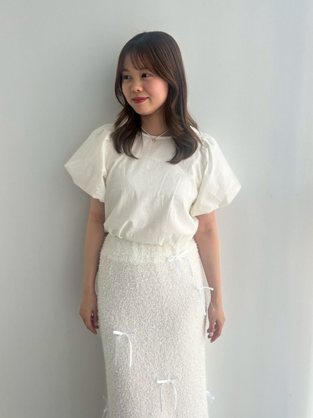 ホワイト系のシャツ/ブラウス、ホワイト系のスカート、シルバー系のバレエシューズを着用したレディースの春コーディネートの2枚目の写真