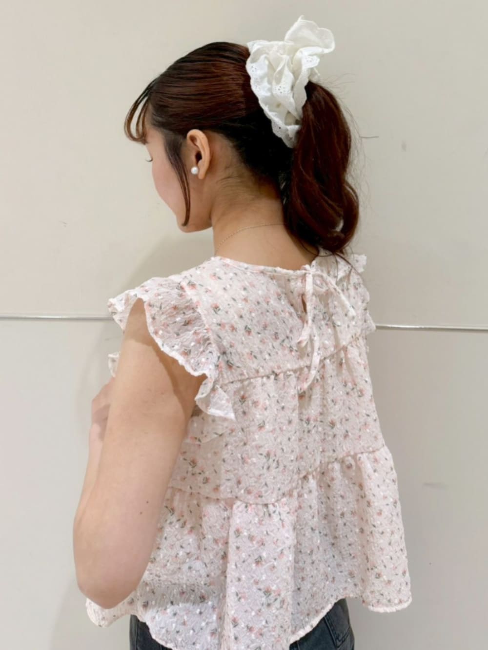 ホワイト系のショルダーバッグ、ブラック系のデニムパンツ、オレンジ系のシャツ/ブラウスを着用したレディースの夏コーディネートの3枚目の写真