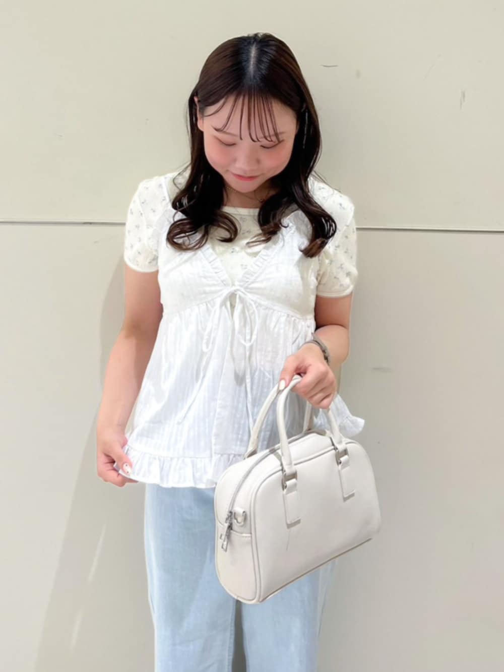 ブルー系のデニムパンツ、ホワイト系のキャミソールを着用したレディースの夏コーディネートの2枚目の写真