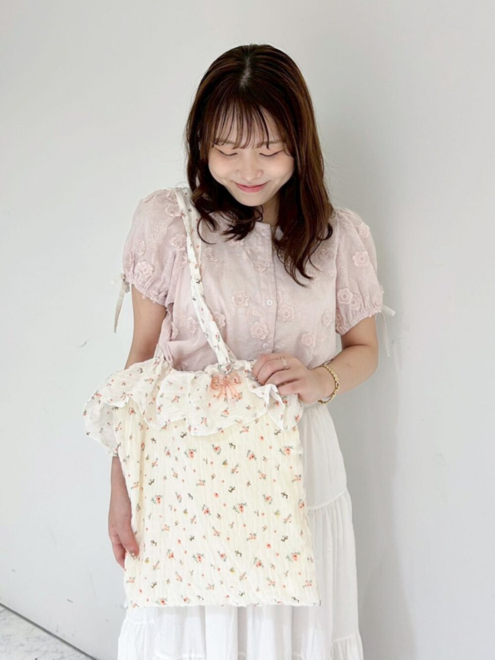 ホワイト系のスカート、ピンク系のシャツ/ブラウス、ホワイト系のトートバッグを着用したレディースの夏コーディネートの2枚目の写真