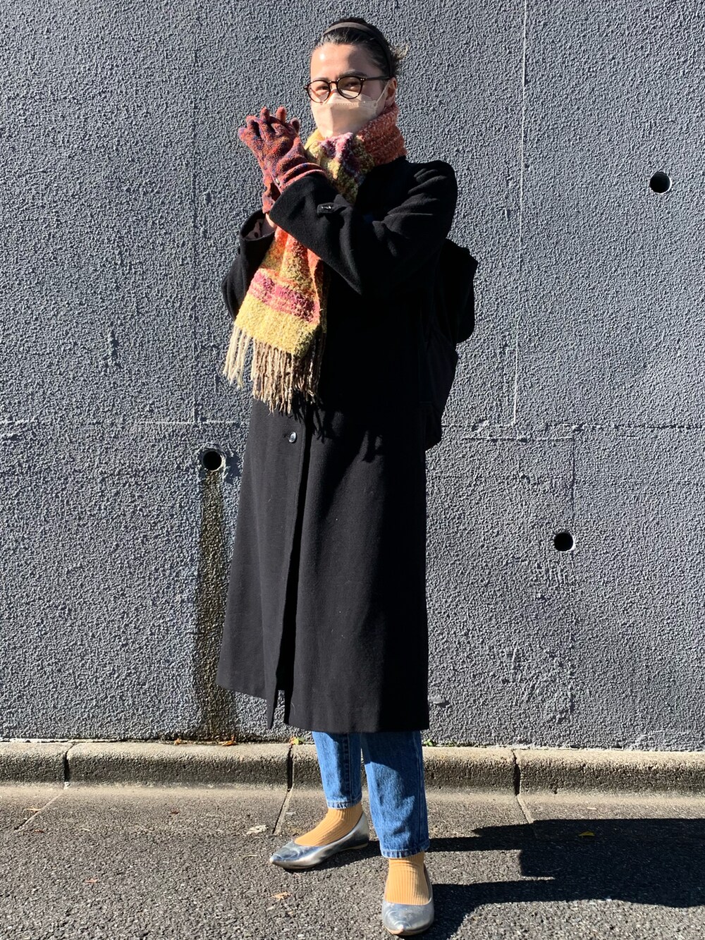 シルバー系のパンプス、ブラウン系の手袋を着用したレディースの冬コーディネートの2枚目の写真