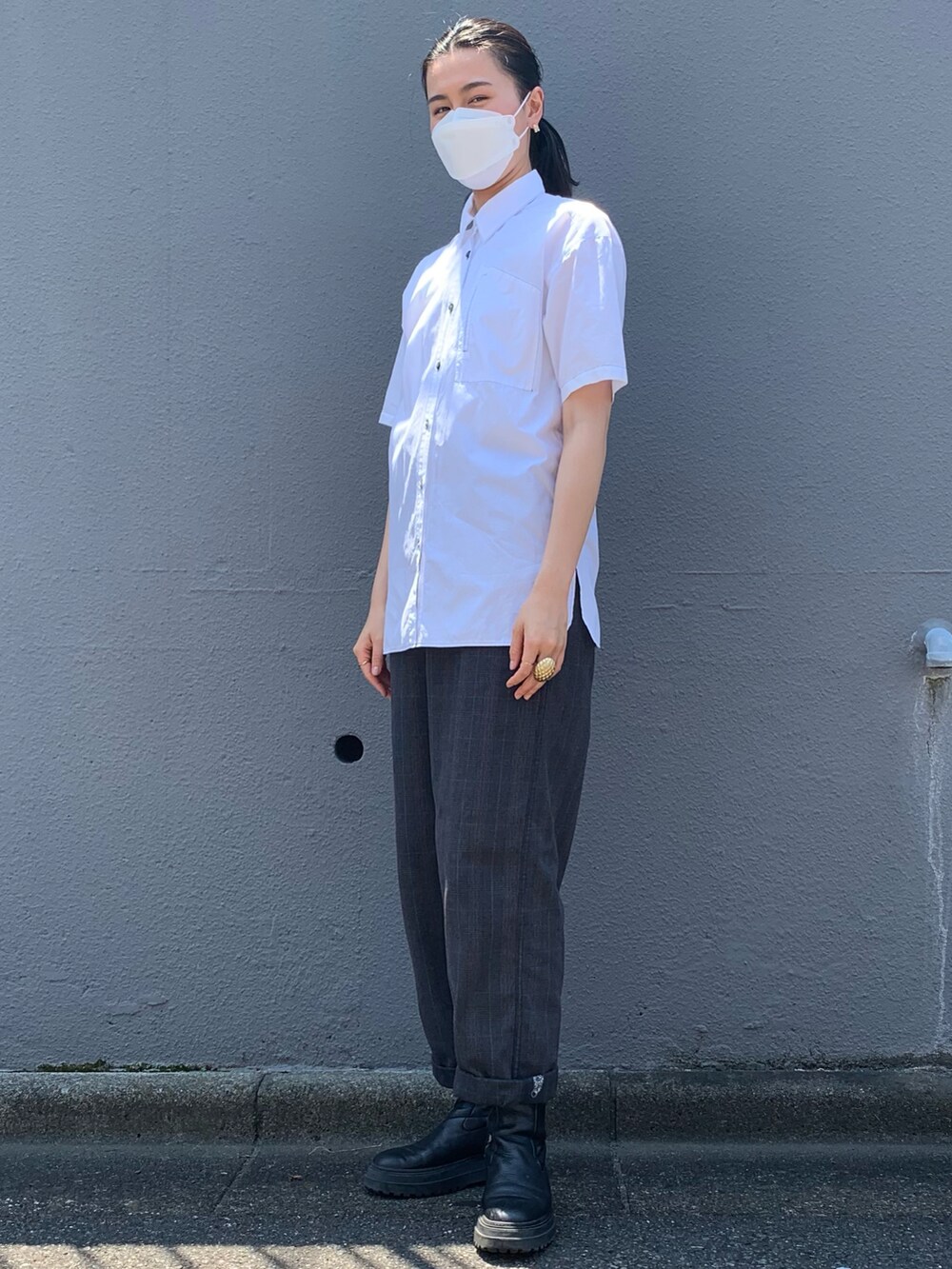 ブラック系のブーツ、ホワイト系のシャツ/ブラウス、レッド系のバッグを着用したレディースの夏コーディネートの2枚目の写真