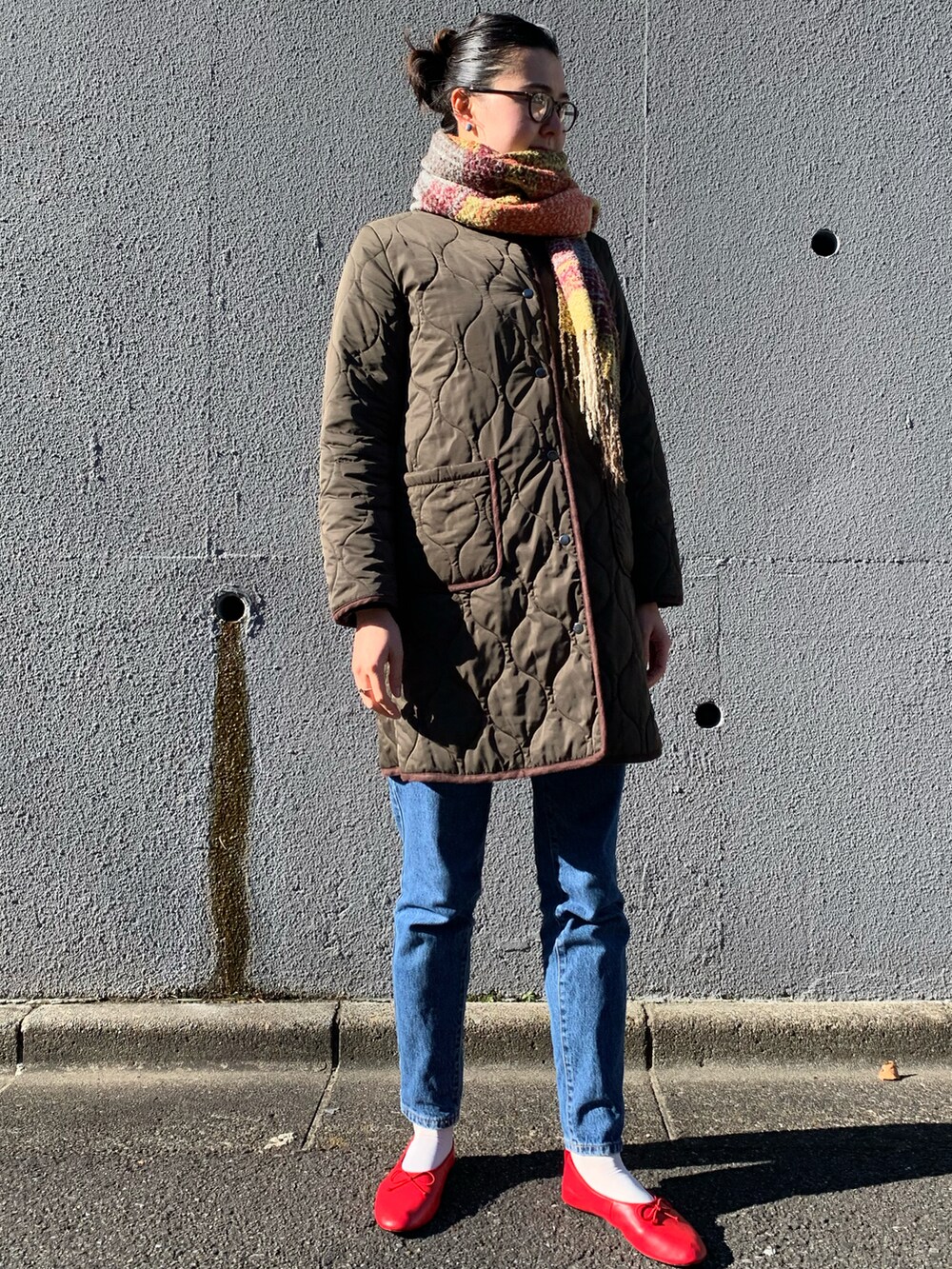 レッド系のパンプス、ブラウン系のベルトを着用したレディースの冬コーディネートの2枚目の写真