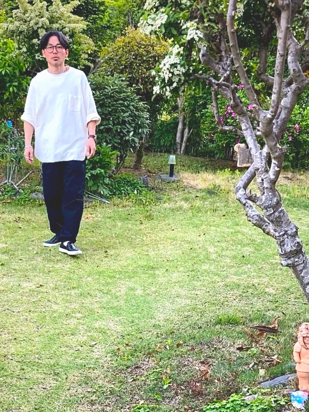 ホワイト系のTシャツ/カットソー、ブラック系のチノパンツ、ブラック系のスリッポンを着用したメンズの春コーディネートの3枚目の写真