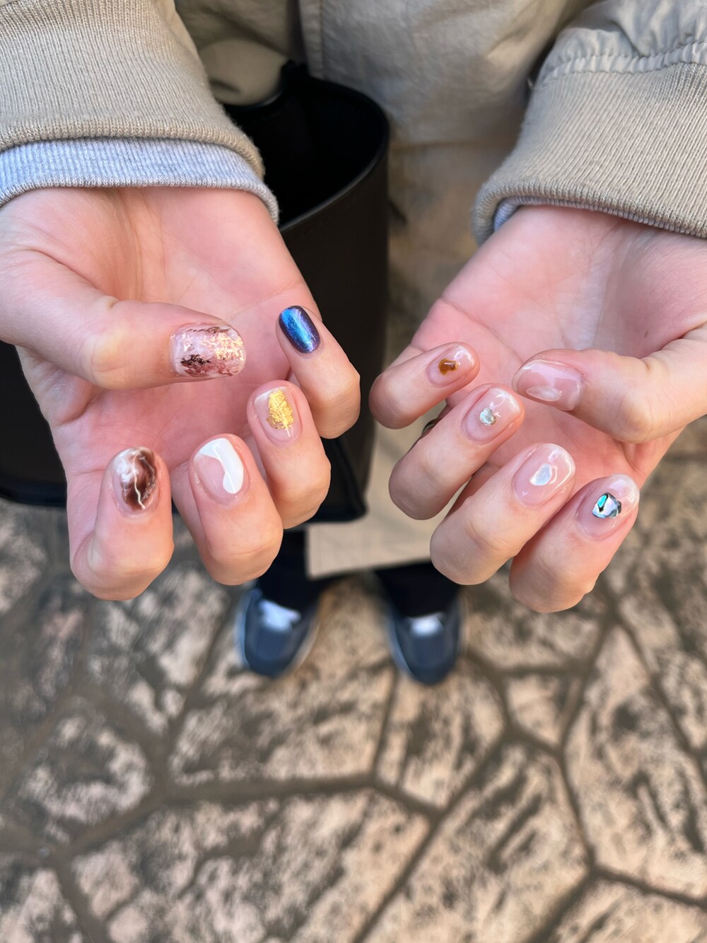 グレー系のパーカー、ベージュ系のジャケット/アウター、ブルー系のスラックスを着用したレディースの冬コーディネートの2枚目の写真