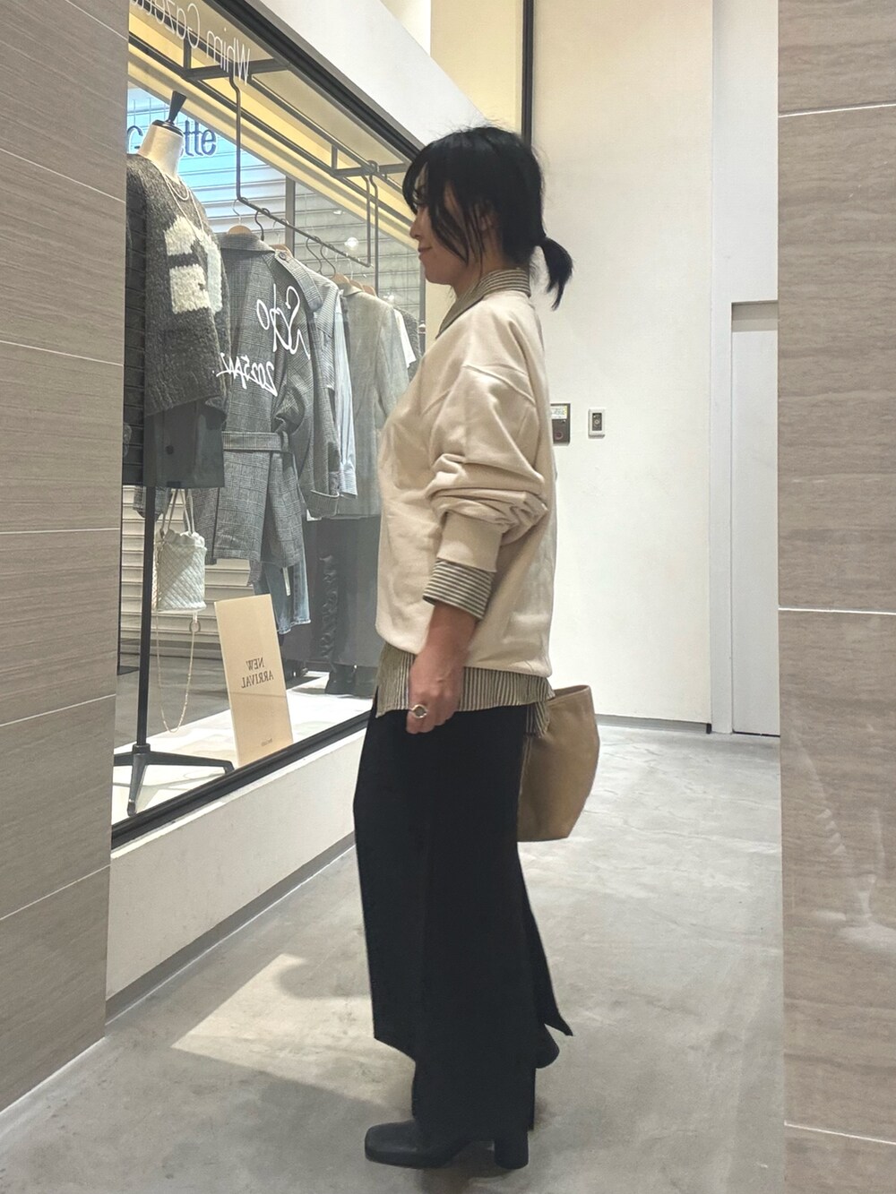 ホワイト系のスウェット、イエロー系のシャツ/ブラウス、ブラック系のブーツを着用したレディースの秋コーディネートの2枚目の写真