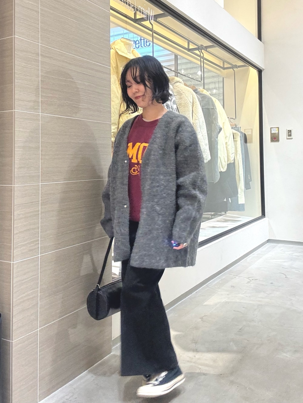 グレー系のその他アウター、ブラック系のショルダーバッグ、ブラック系のスカートを着用したレディースの秋コーディネートの2枚目の写真