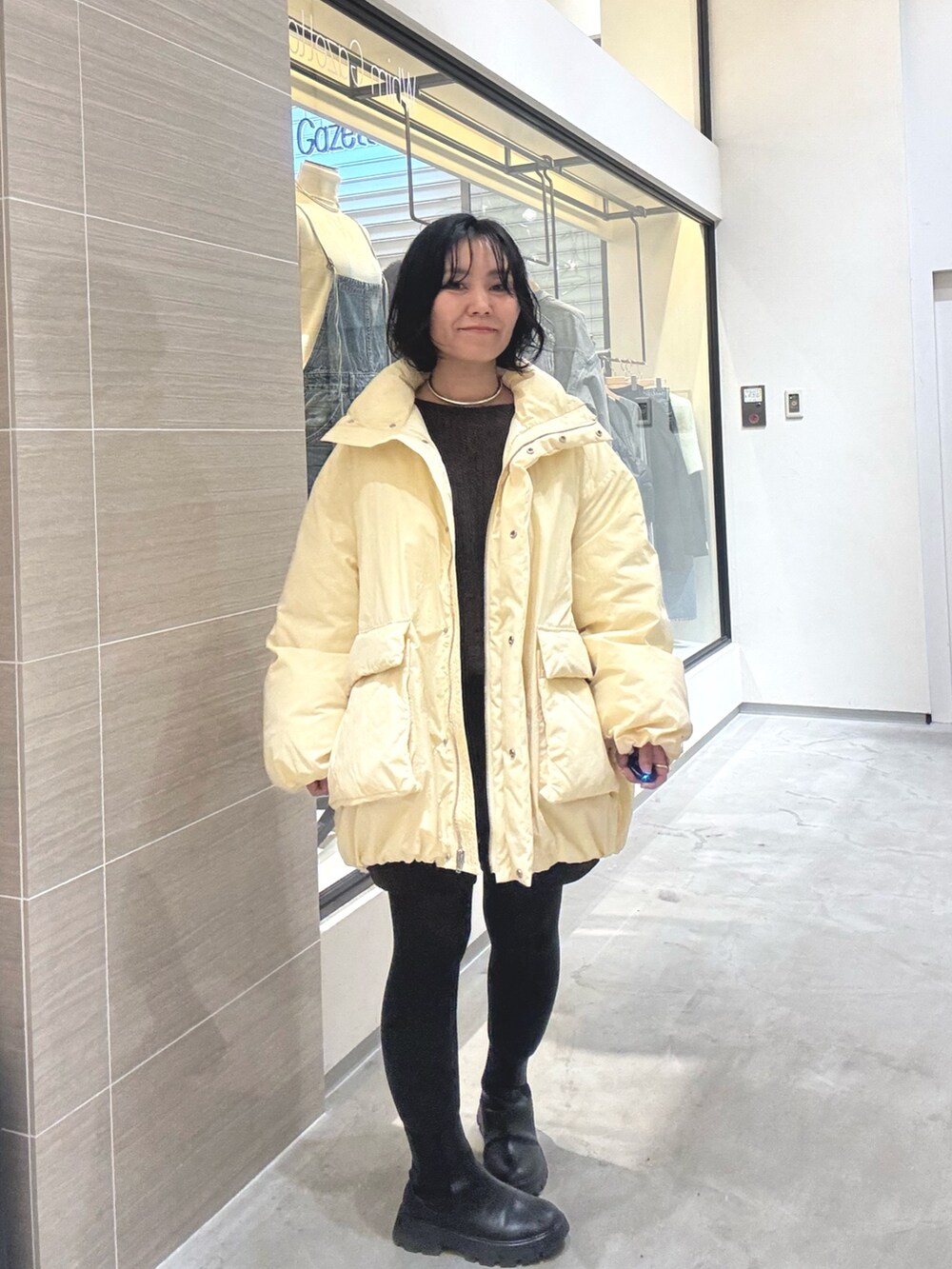 イエロー系のダウンジャケット/コート、ブラウン系のその他パンツ、ブラック系のブーツを着用したレディースの秋コーディネートの6枚目の写真