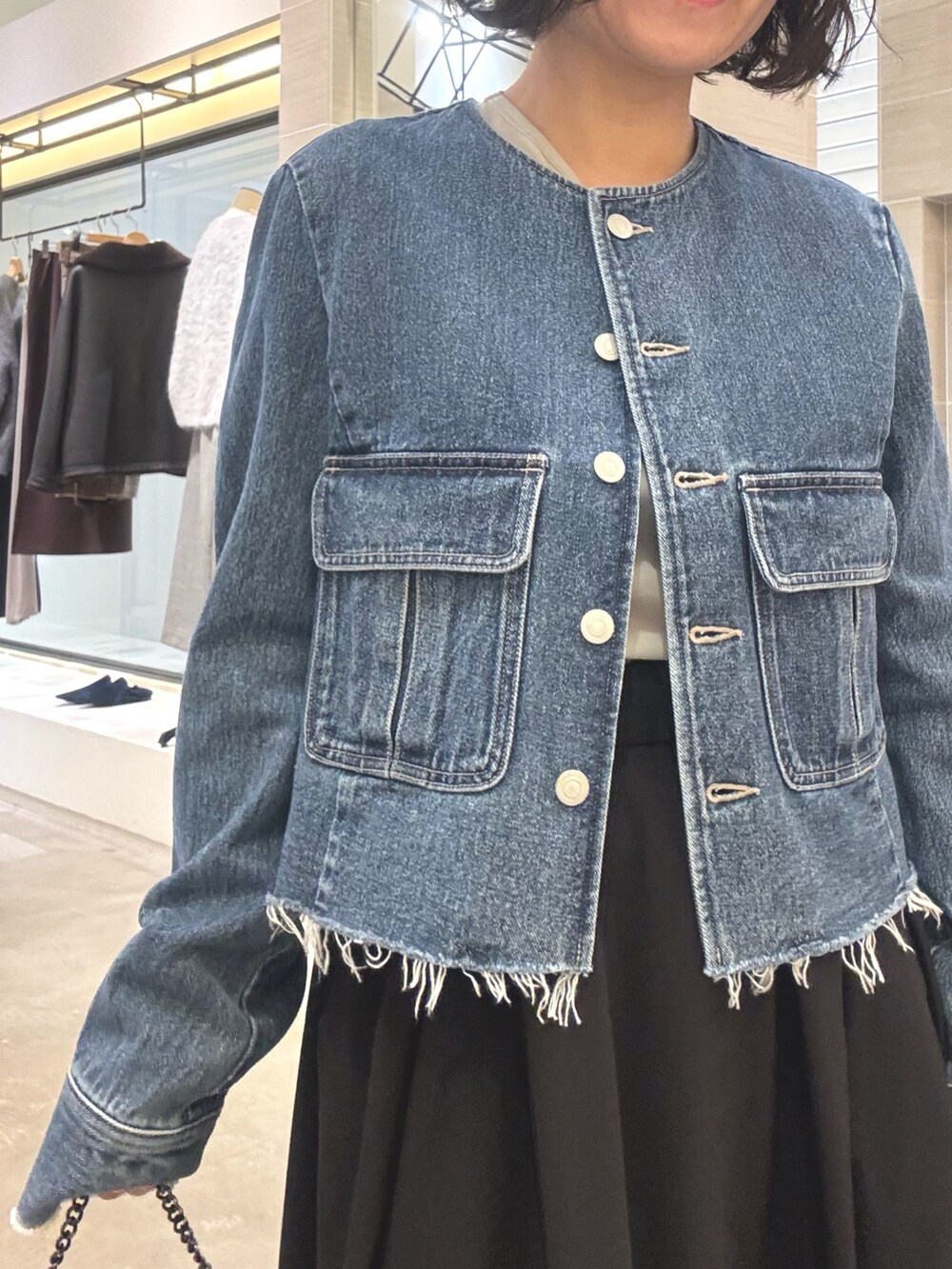 ブルー系のデニムジャケット、ブラック系のスカート、グレー系のショルダーバッグを着用したレディースの冬コーディネートの6枚目の写真