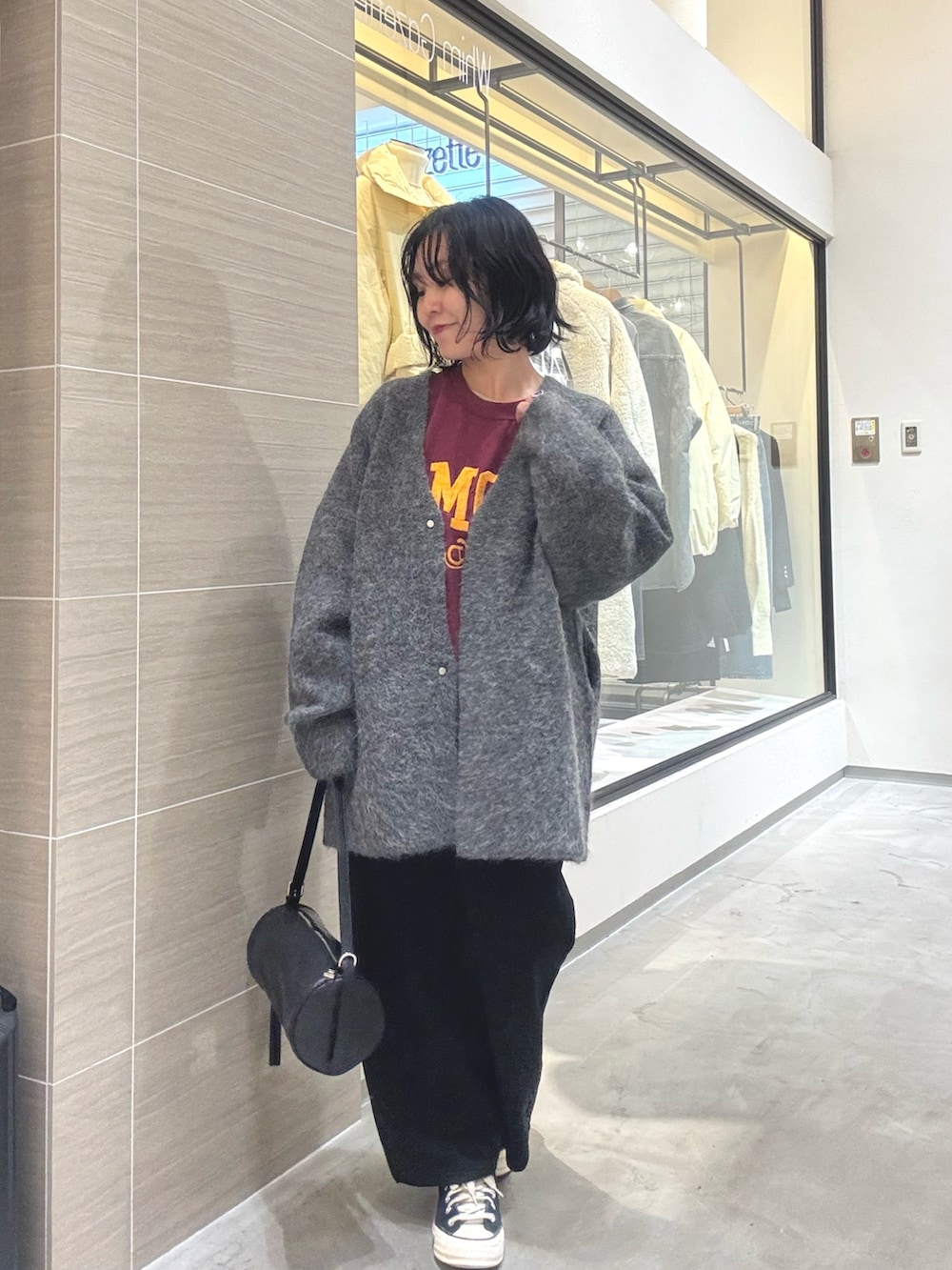 グレー系のその他アウター、ブラック系のショルダーバッグ、ブラック系のスカートを着用したレディースの秋コーディネートの6枚目の写真