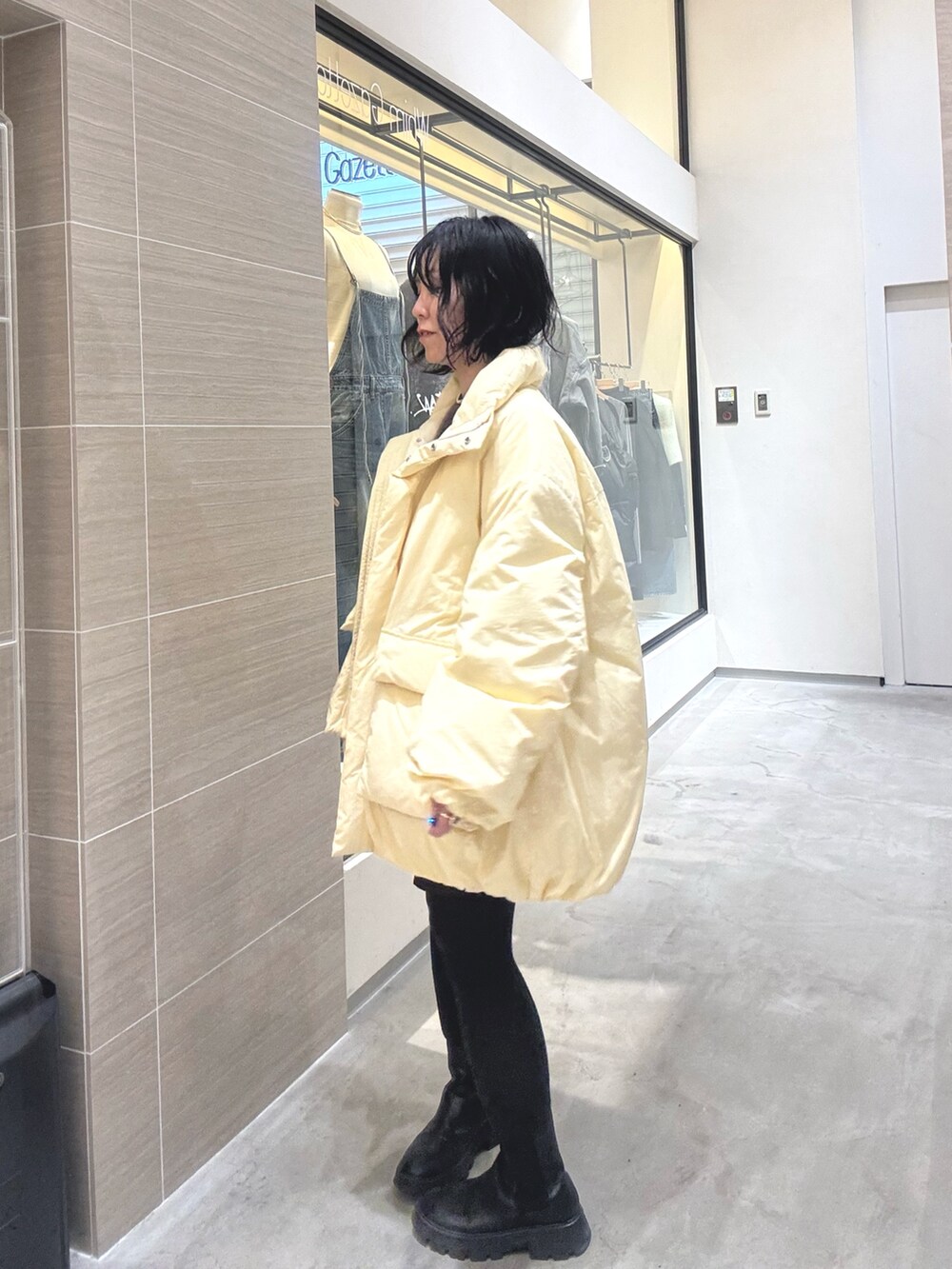 イエロー系のダウンジャケット/コート、ブラウン系のその他パンツ、ブラック系のブーツを着用したレディースの秋コーディネートの3枚目の写真