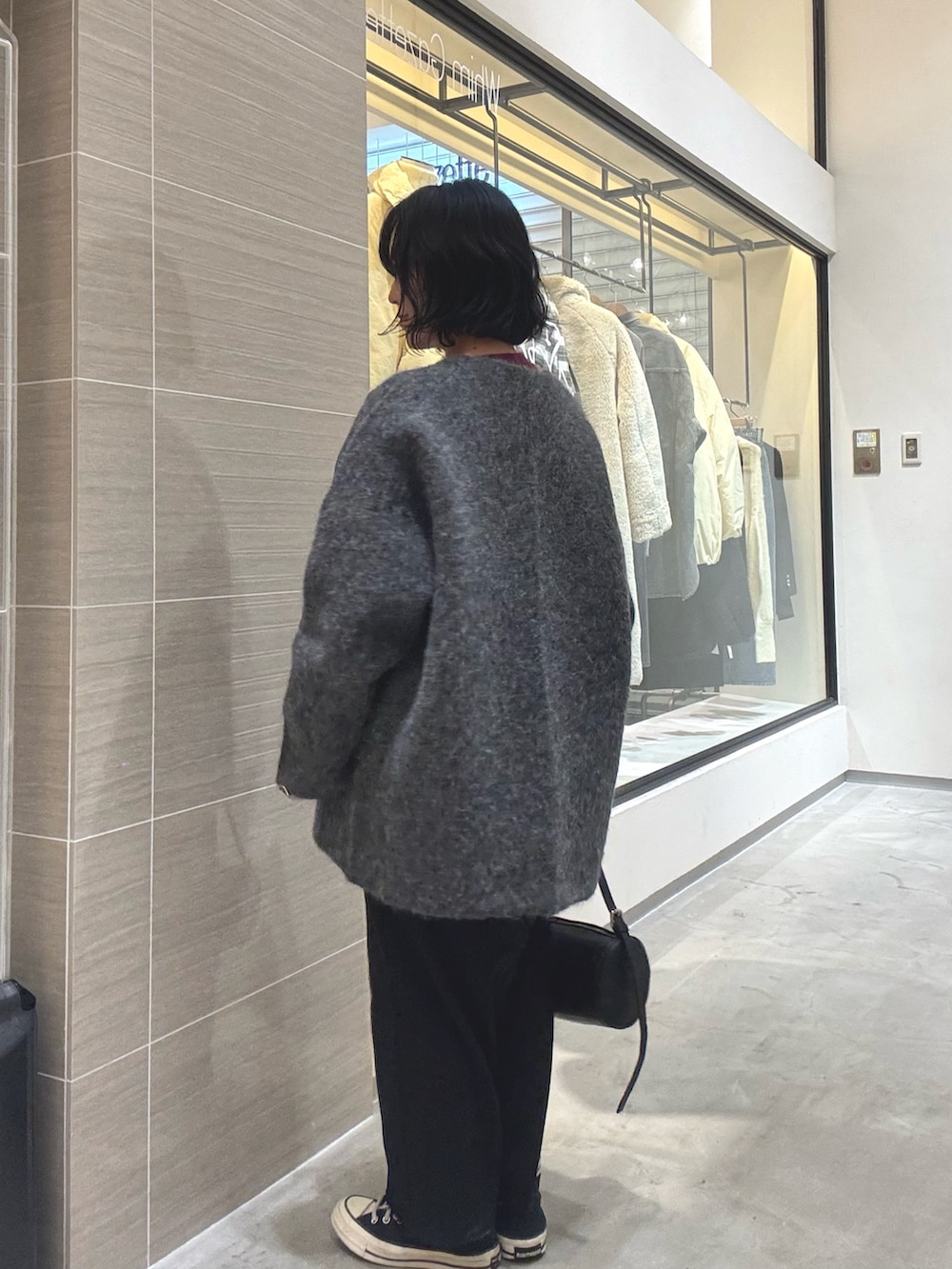 グレー系のその他アウター、ブラック系のショルダーバッグ、ブラック系のスカートを着用したレディースの秋コーディネートの3枚目の写真