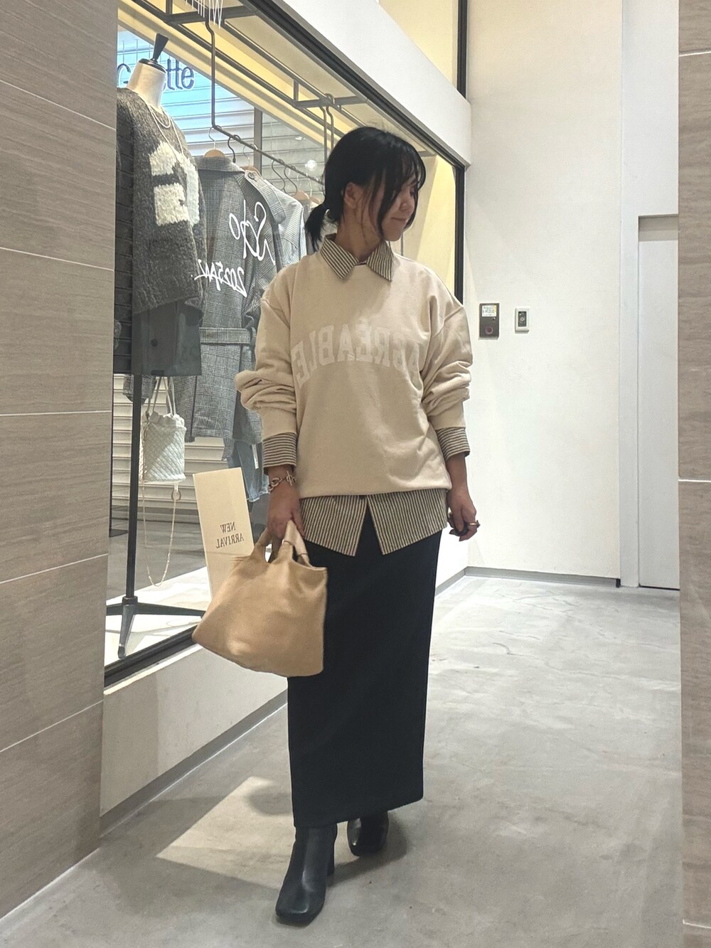 ホワイト系のスウェット、イエロー系のシャツ/ブラウス、ブラック系のブーツを着用したレディースの秋コーディネートの7枚目の写真