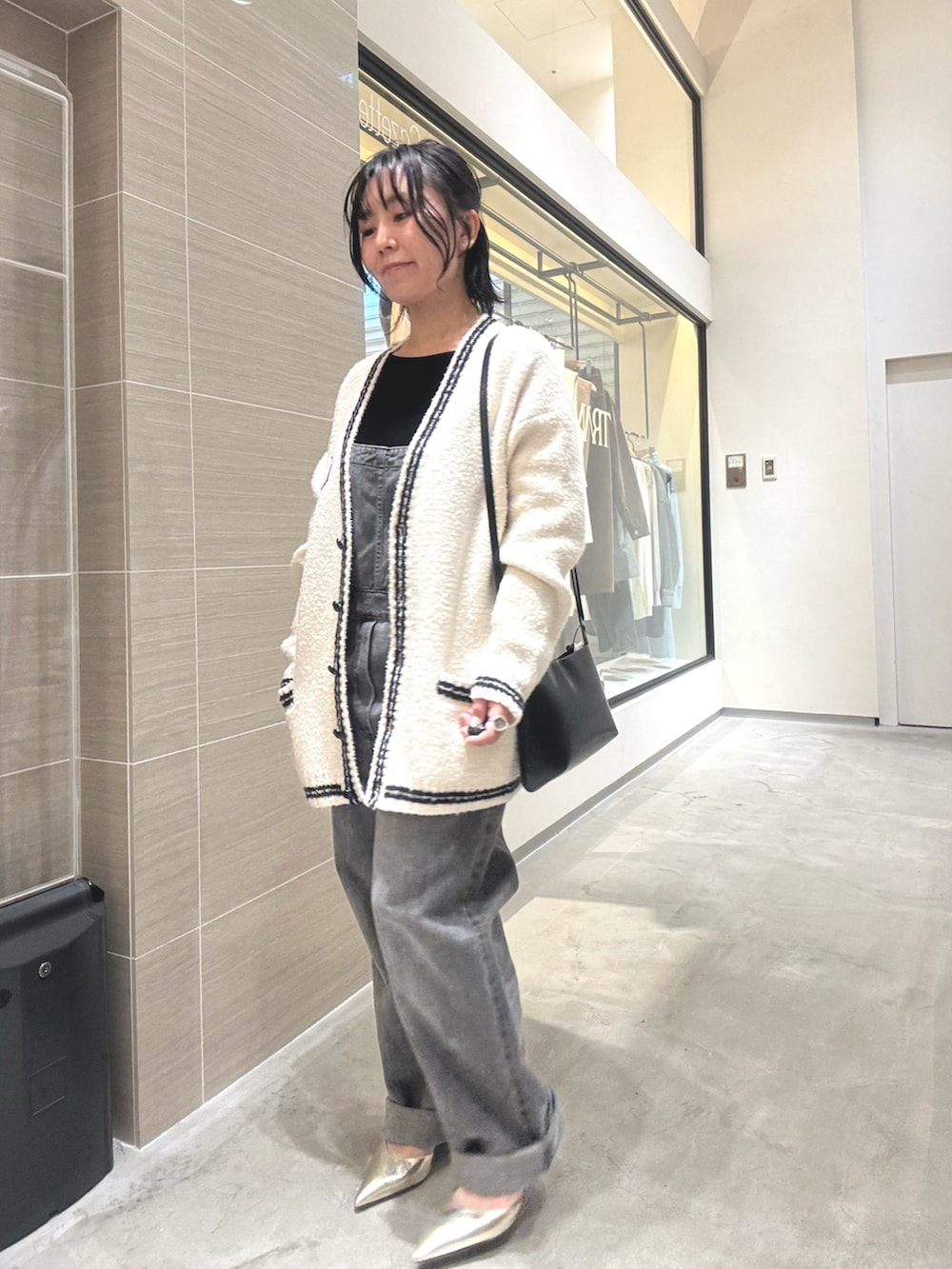 ゴールド系のパンプス、グレー系のつなぎ/オールインワン、ブラック系のショルダーバッグを着用したレディースの夏コーディネートの2枚目の写真