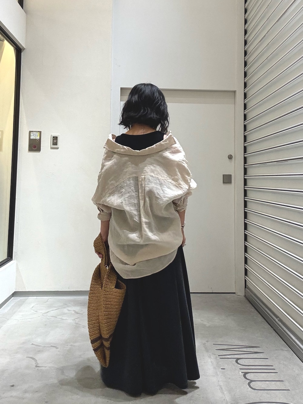 ベージュ系のシャツ/ブラウス、ブラック系のスカート、ブラック系のサンダルを着用したレディースの春コーディネートの3枚目の写真