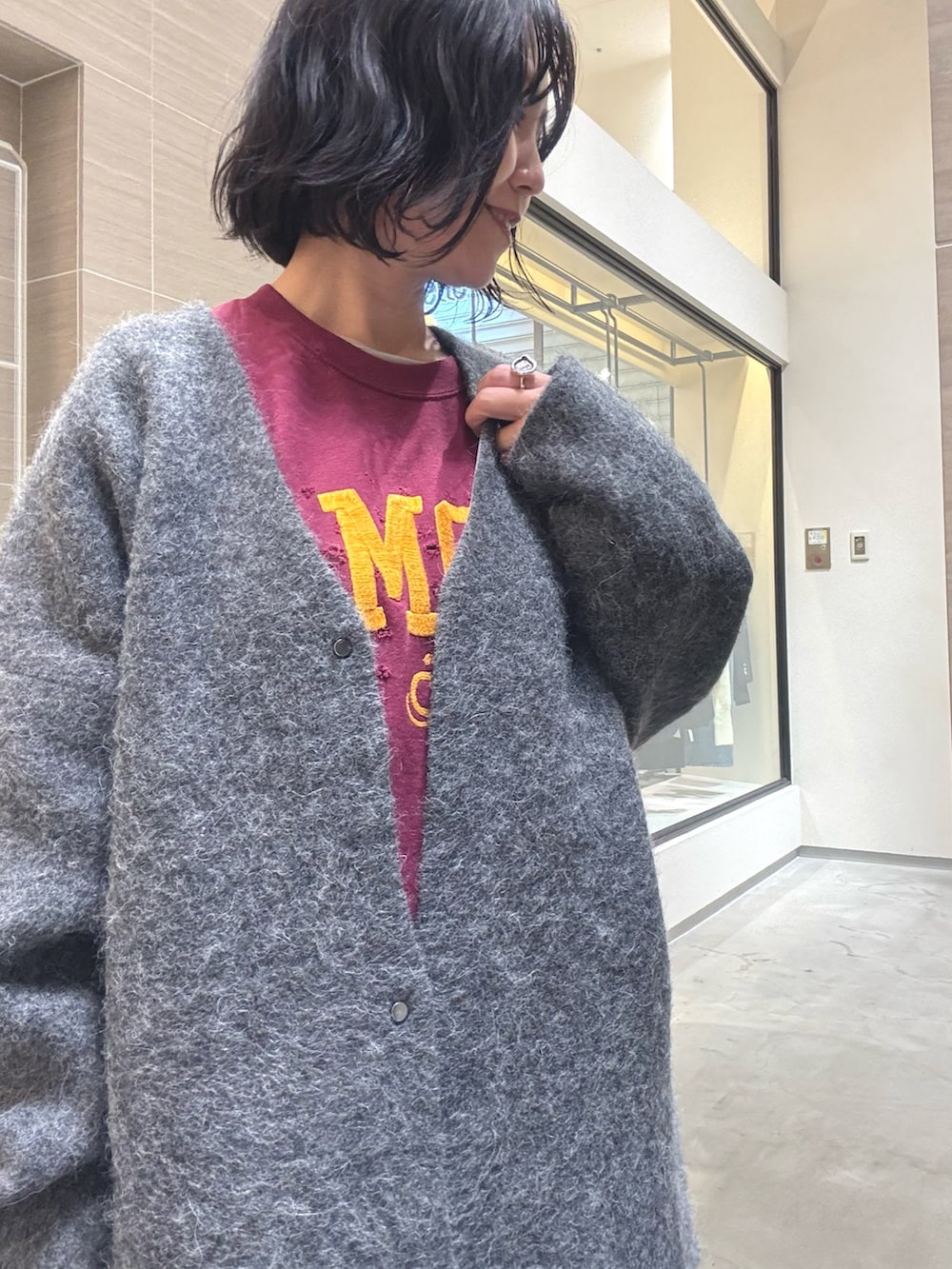 グレー系のその他アウター、ブラック系のショルダーバッグ、ブラック系のスカートを着用したレディースの秋コーディネートの7枚目の写真