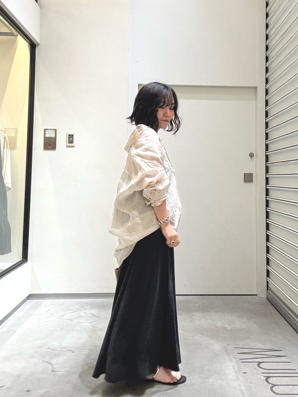 ベージュ系のシャツ/ブラウス、ブラック系のスカート、ブラック系のサンダルを着用したレディースの春コーディネートの4枚目の写真