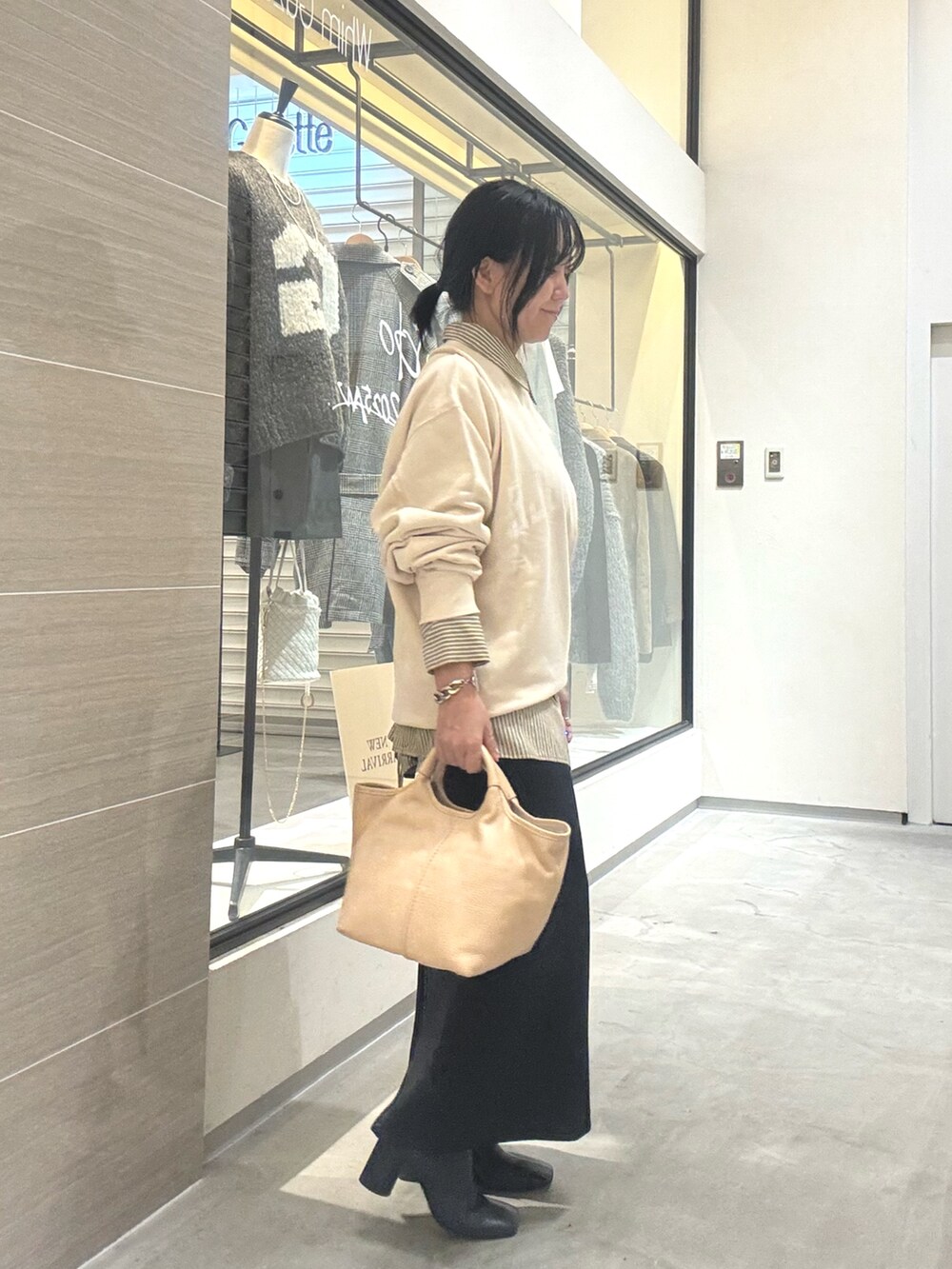 ホワイト系のスウェット、イエロー系のシャツ/ブラウス、ブラック系のブーツを着用したレディースの秋コーディネートの5枚目の写真