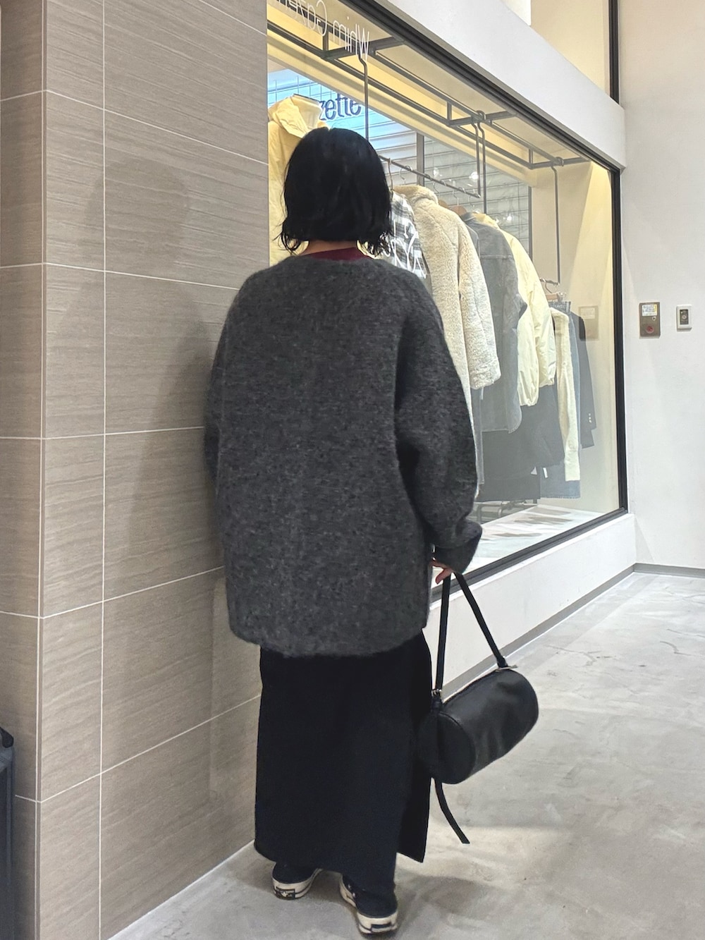 グレー系のその他アウター、ブラック系のショルダーバッグ、ブラック系のスカートを着用したレディースの秋コーディネートの4枚目の写真