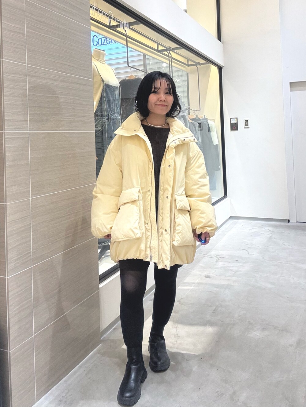 イエロー系のダウンジャケット/コート、ブラウン系のその他パンツ、ブラック系のブーツを着用したレディースの秋コーディネートの7枚目の写真