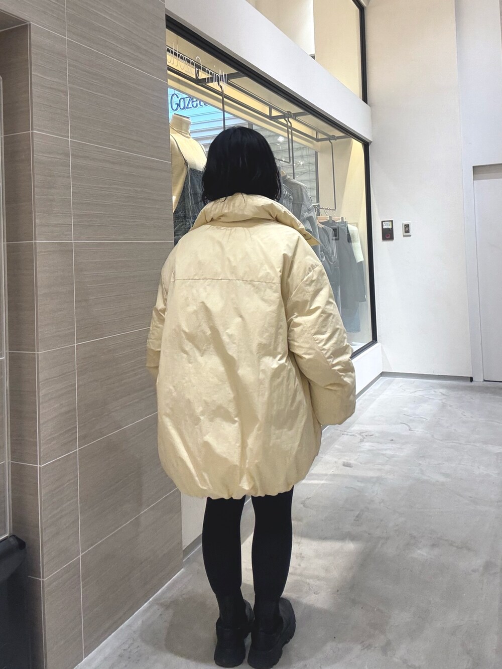 イエロー系のダウンジャケット/コート、ブラウン系のその他パンツ、ブラック系のブーツを着用したレディースの秋コーディネートの4枚目の写真