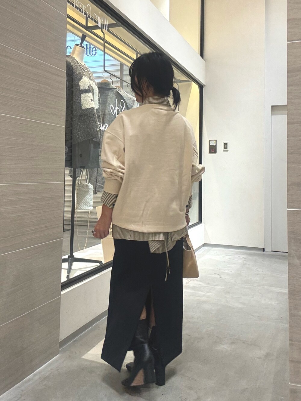 ホワイト系のスウェット、イエロー系のシャツ/ブラウス、ブラック系のブーツを着用したレディースの秋コーディネートの3枚目の写真