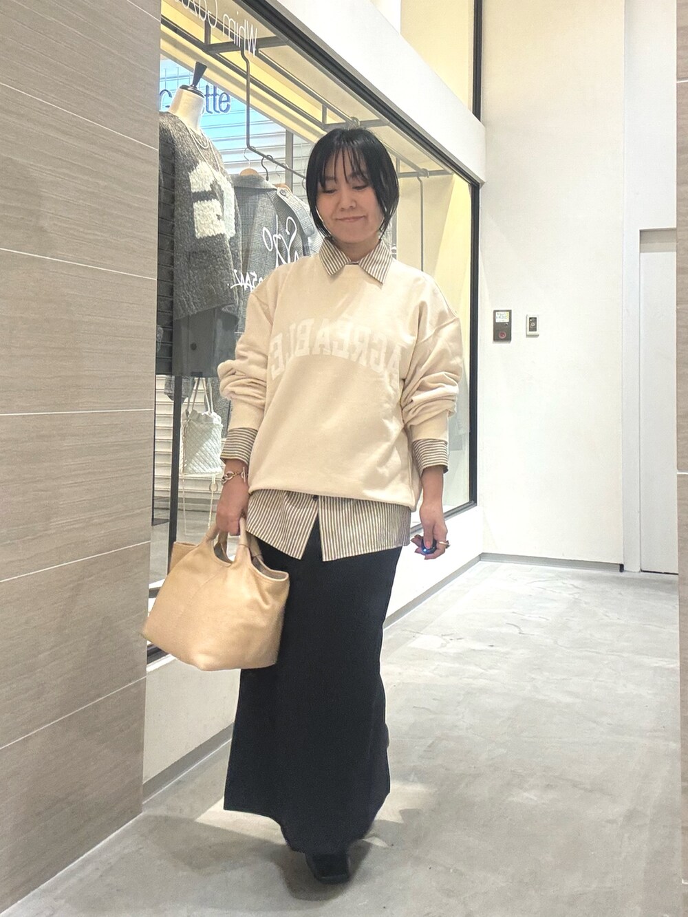 ホワイト系のスウェット、イエロー系のシャツ/ブラウス、ブラック系のブーツを着用したレディースの秋コーディネートの6枚目の写真