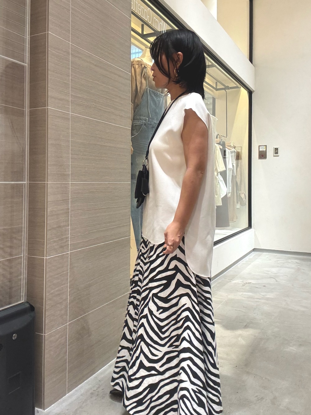 ホワイト系のシャツ/ブラウス、ホワイト系のスカート、ブラウン系のパンプスを着用したレディースの夏コーディネートの3枚目の写真