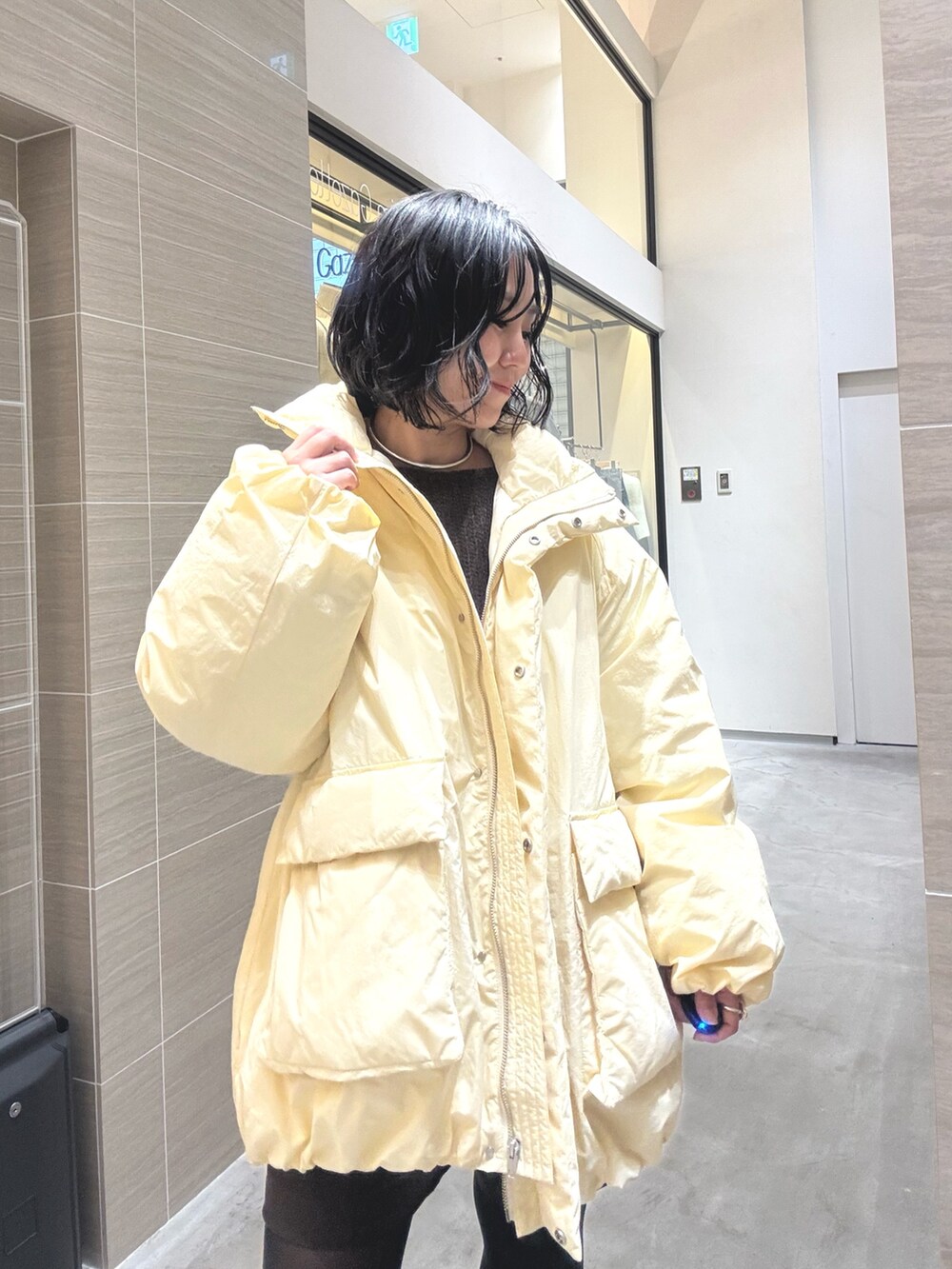 イエロー系のダウンジャケット/コート、ブラウン系のその他パンツ、ブラック系のブーツを着用したレディースの秋コーディネートの8枚目の写真